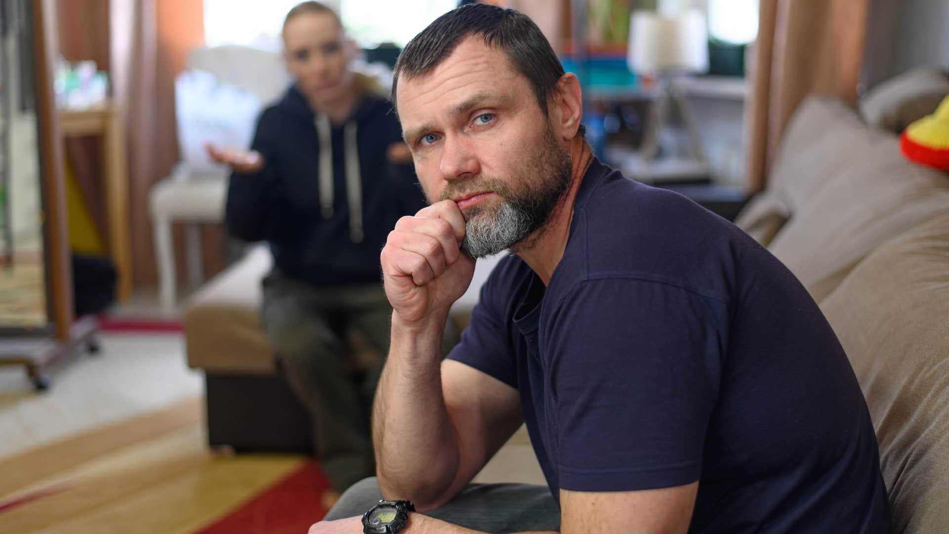 Man looking frustrated on the couch.