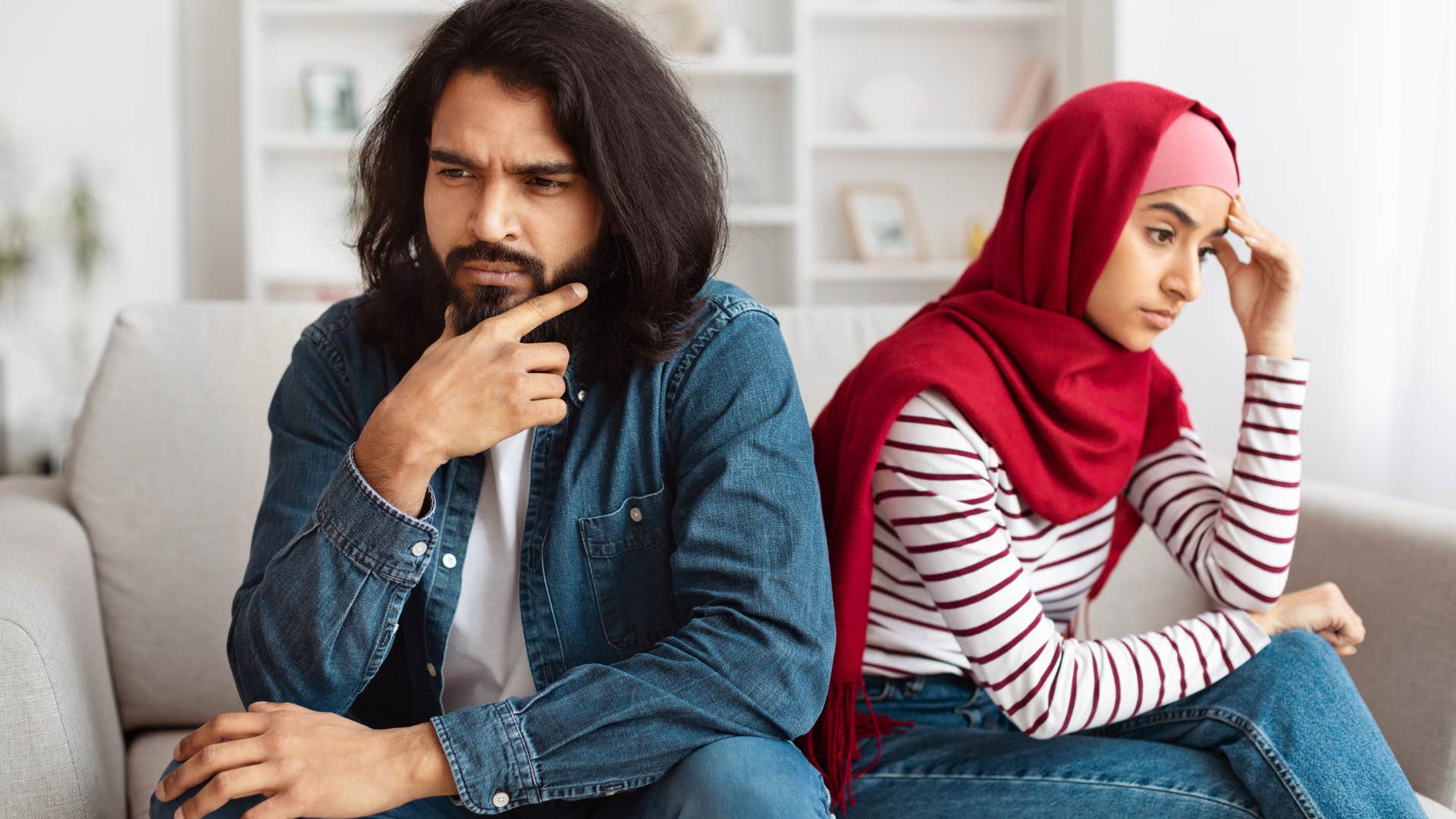 Man looking annoyed while his partner sits behind him.