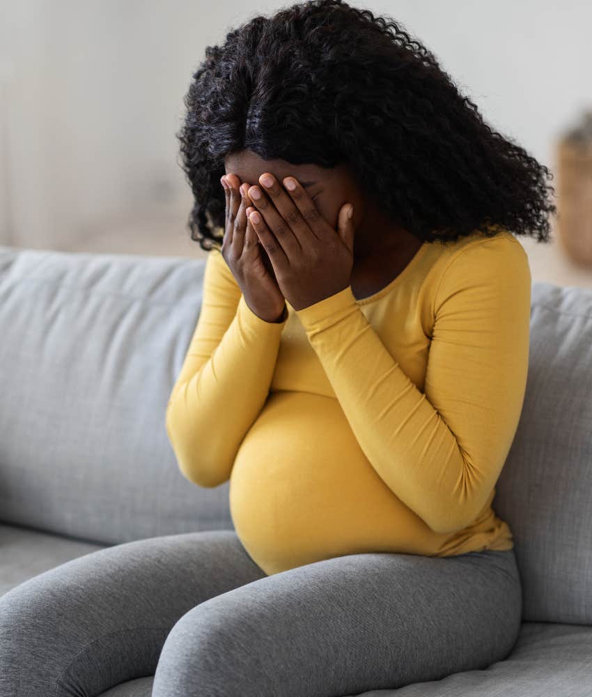 pregnant woman crying on couch