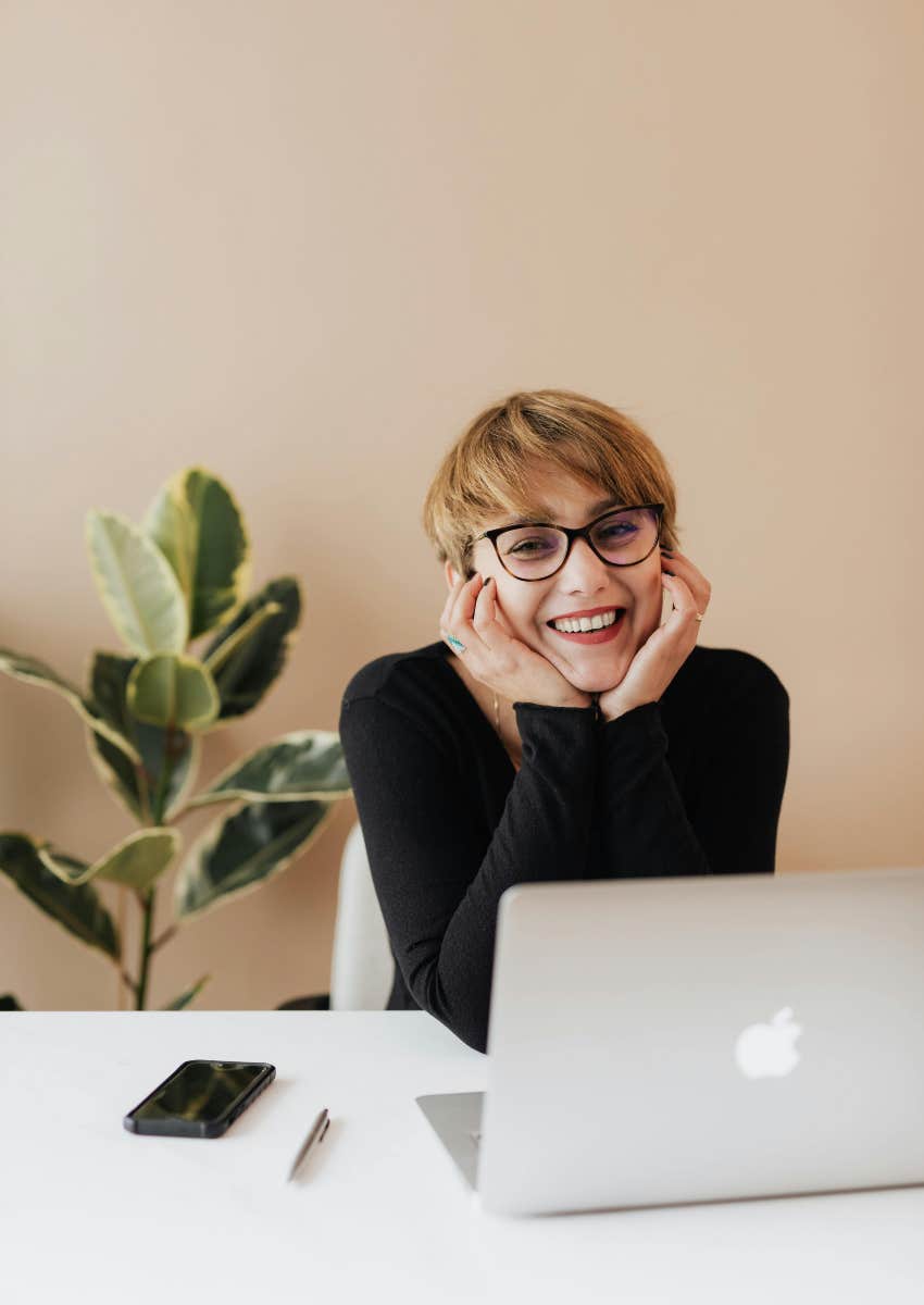 pretty employee sitting at desk with laptop