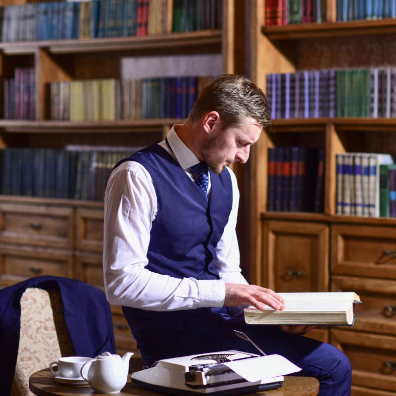 professor reading book in library