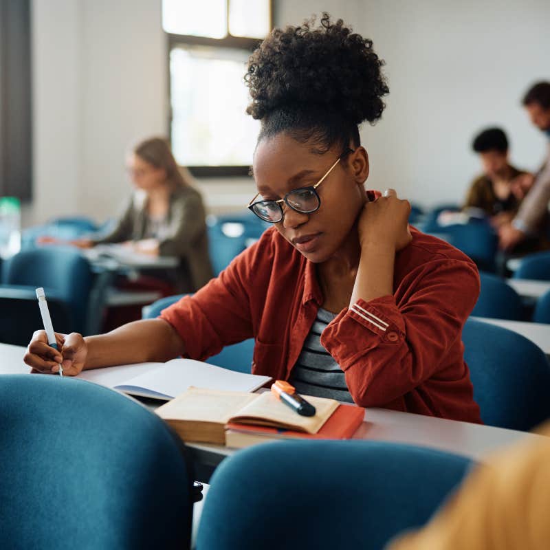 college student reading notebook in class