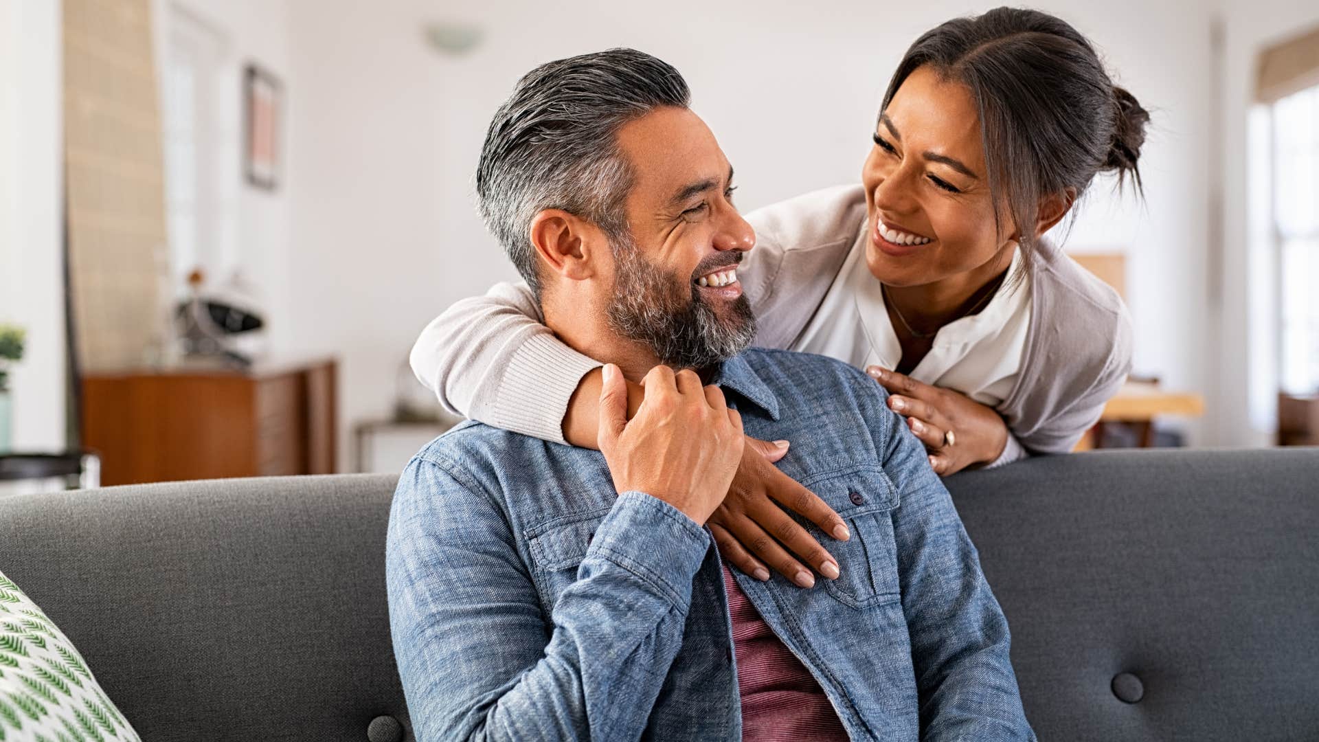 Romantic couple hugging at home.