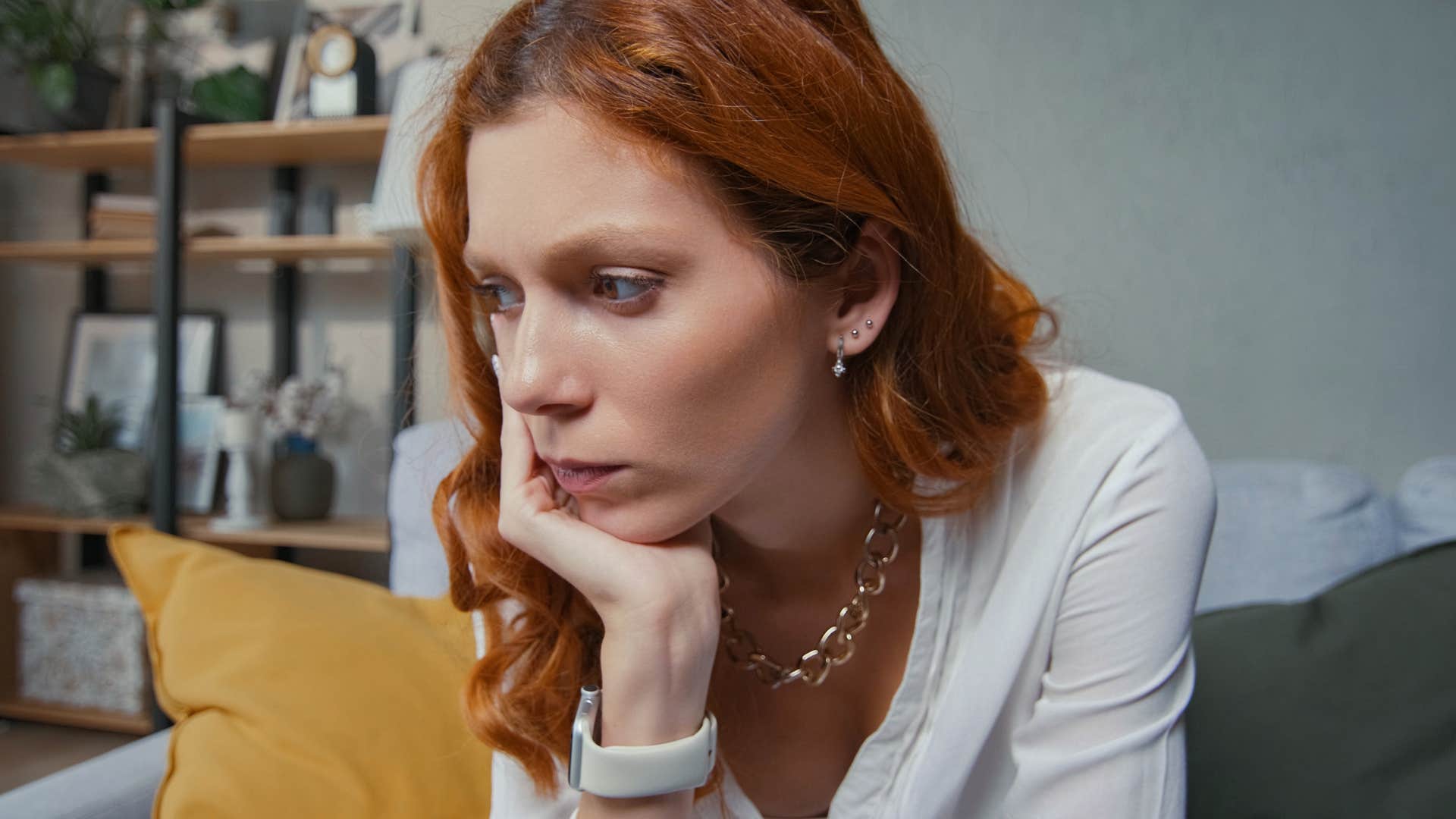 Woman looking upset sitting on her couch