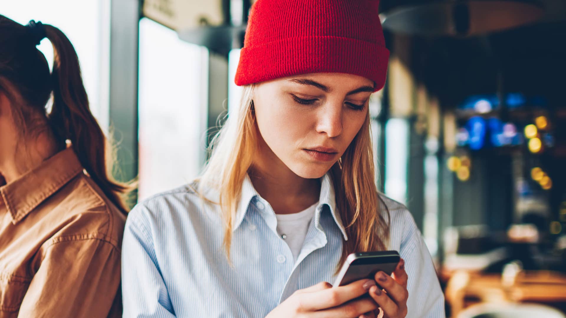 Woman looking frustrated while texting on her phone