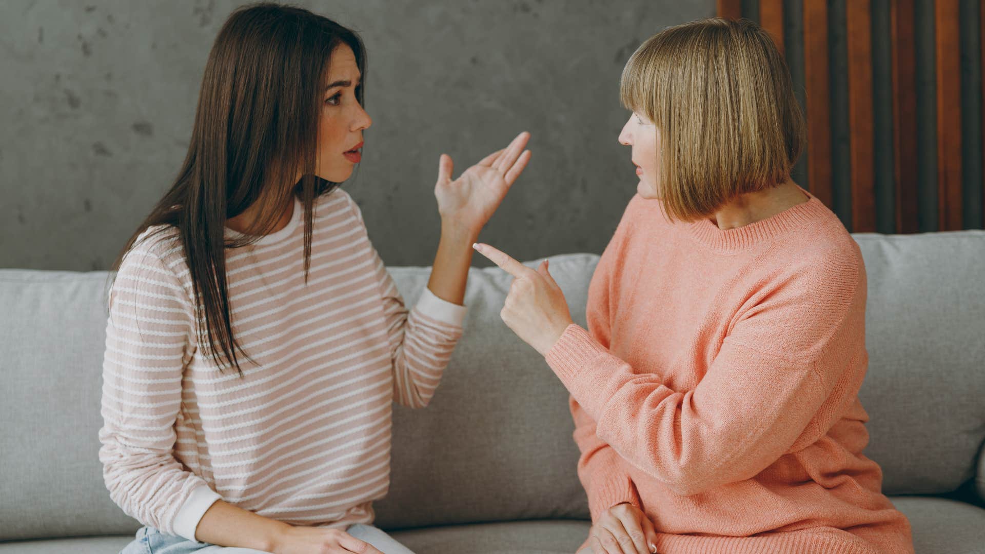 Woman looking upset while her mother points at her.