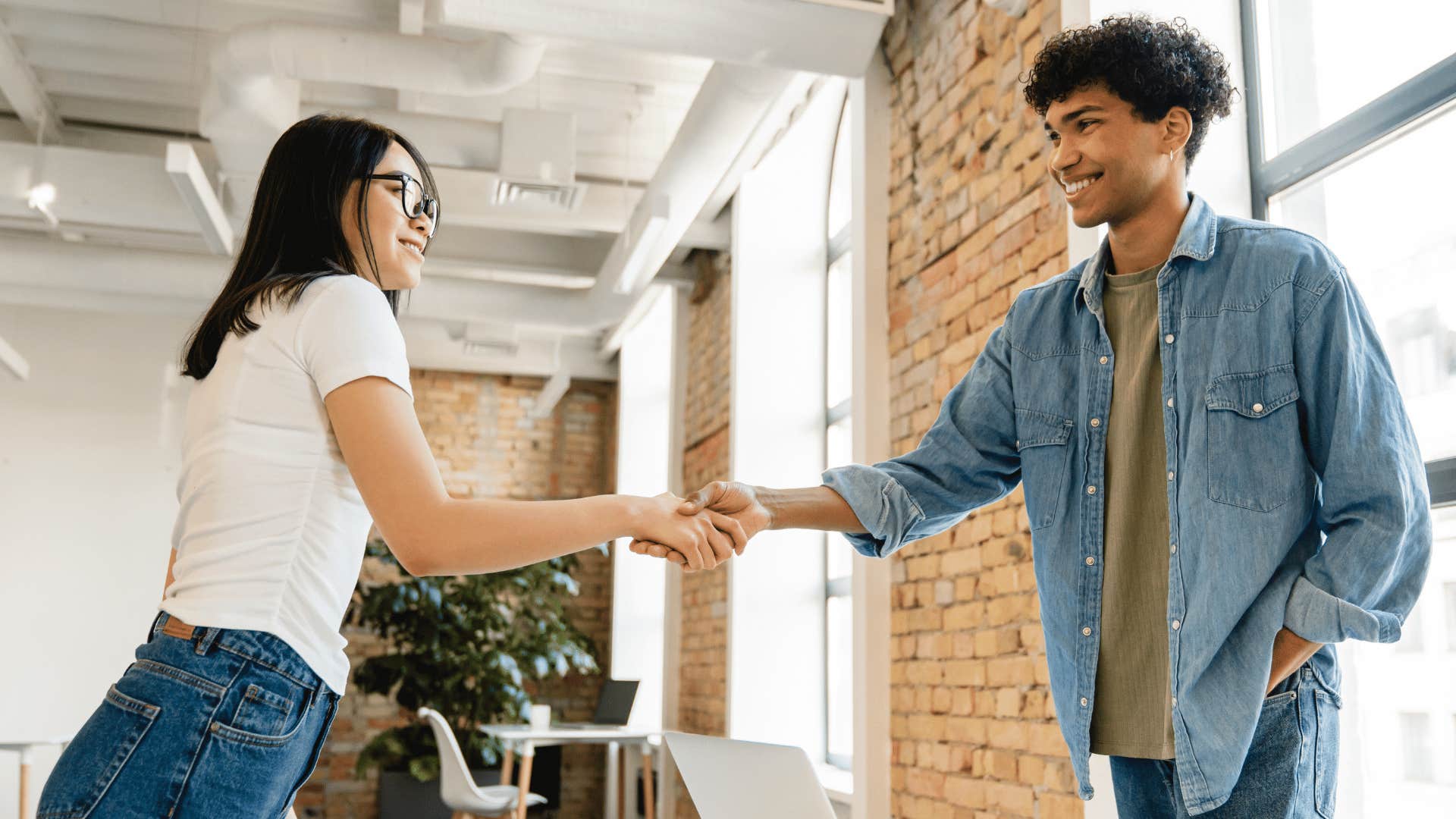 two young workers shaking hands