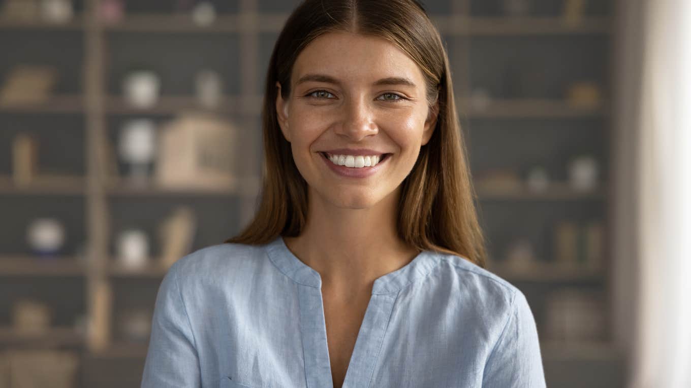 Woman smiling at the camera inside her house.