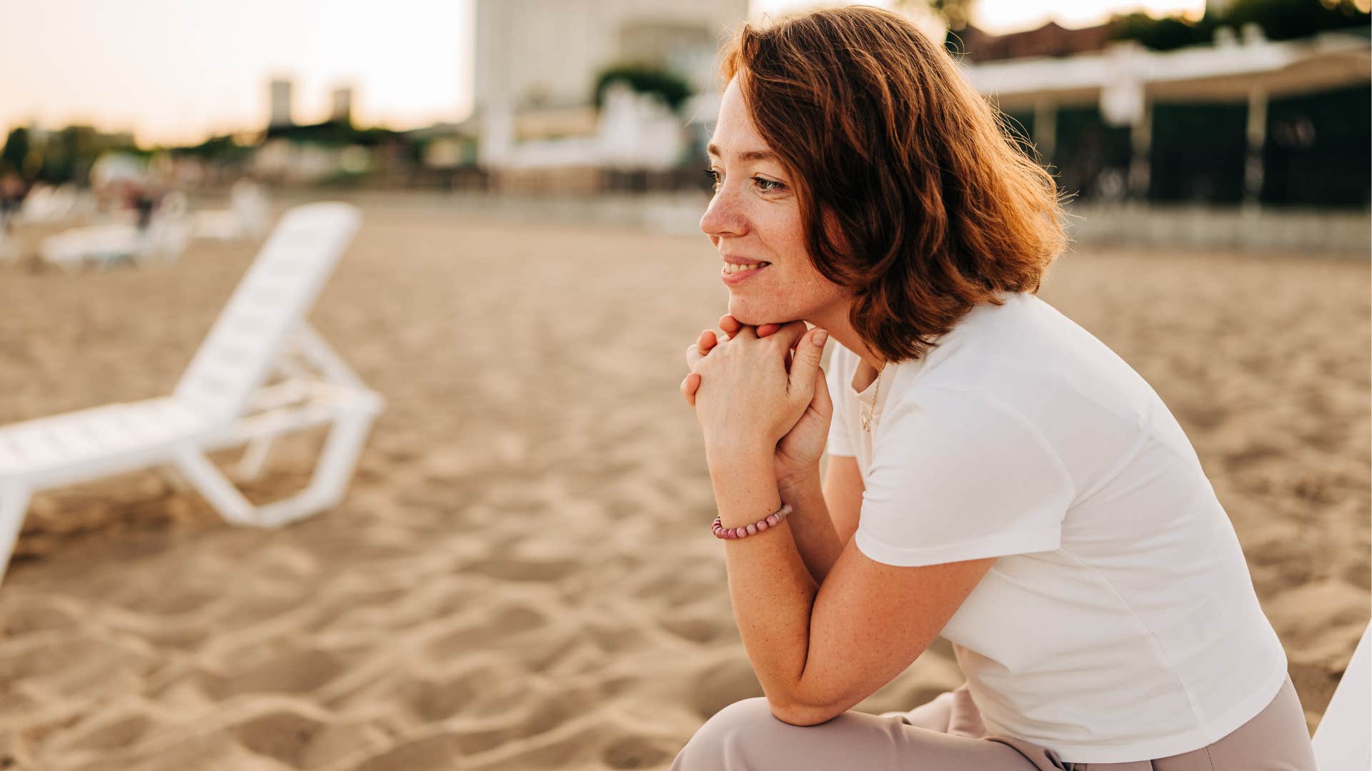 Woman smiling and relaxing at the beach.