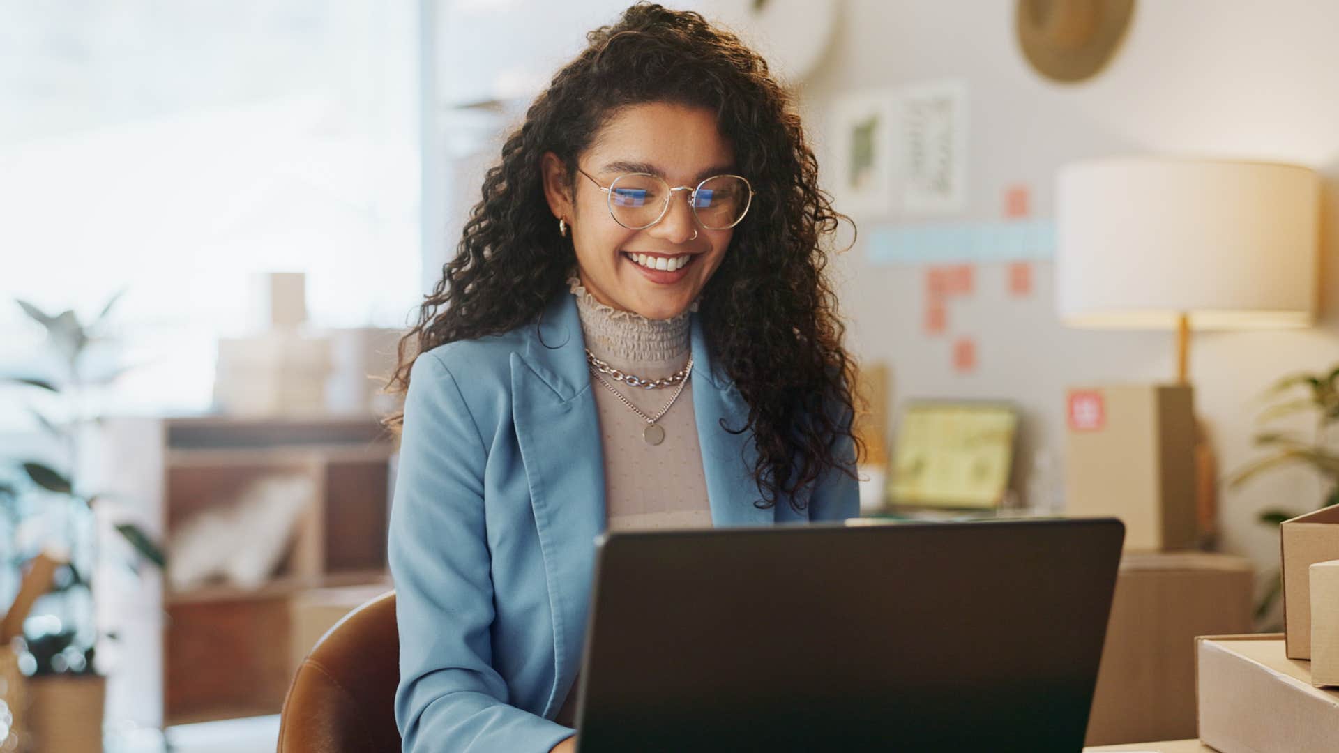 Woman smiling while working on her laptop. 