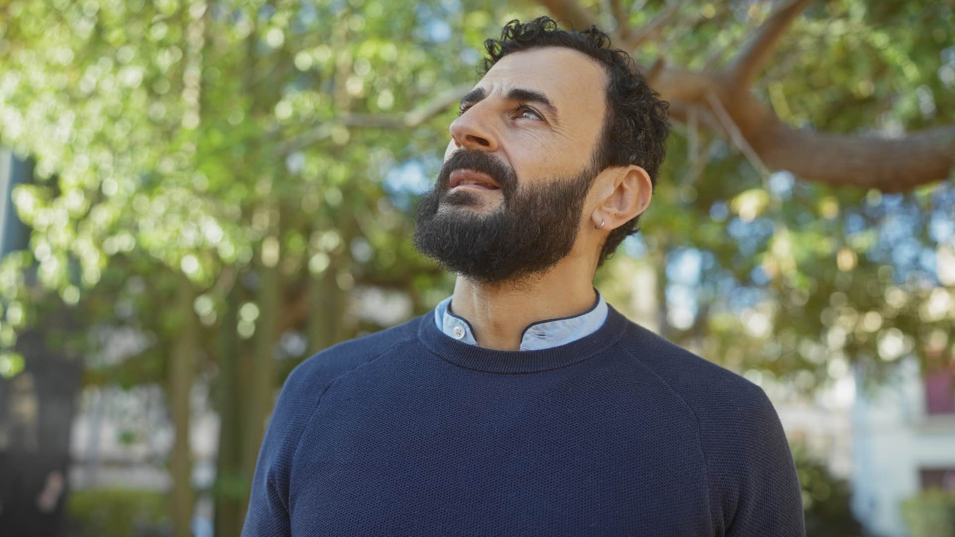 Man thinking while walking around in a park.