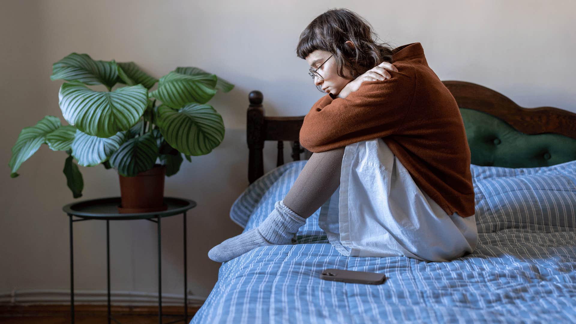 girl sitting on bed upset 