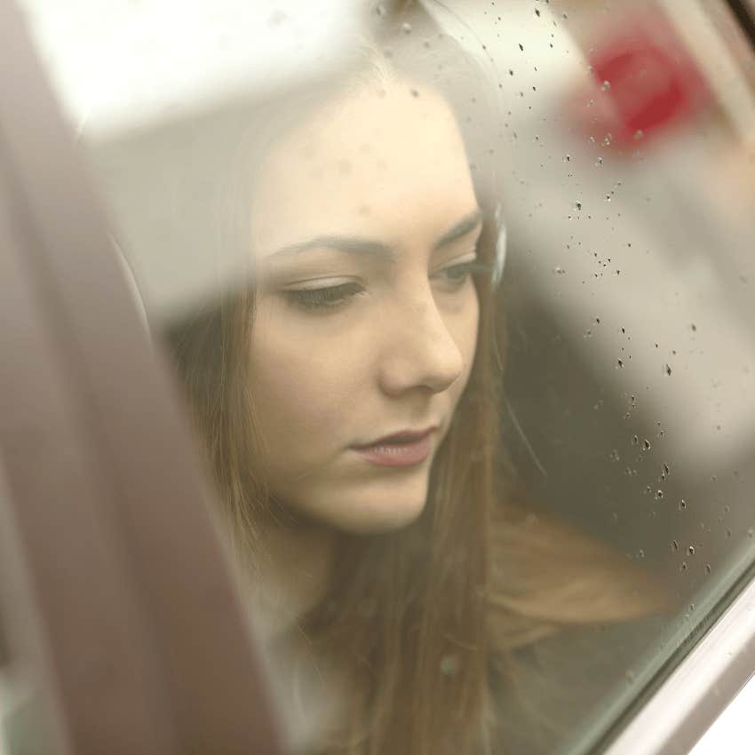 sad woman looking out of a car window