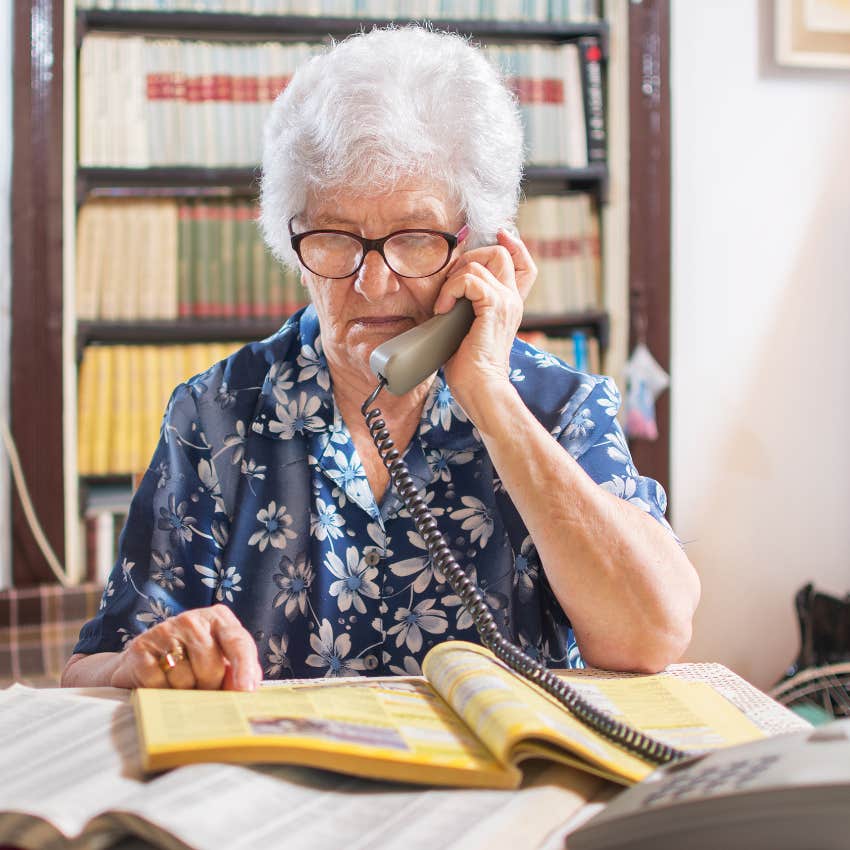 Senior woman reading from the phone book