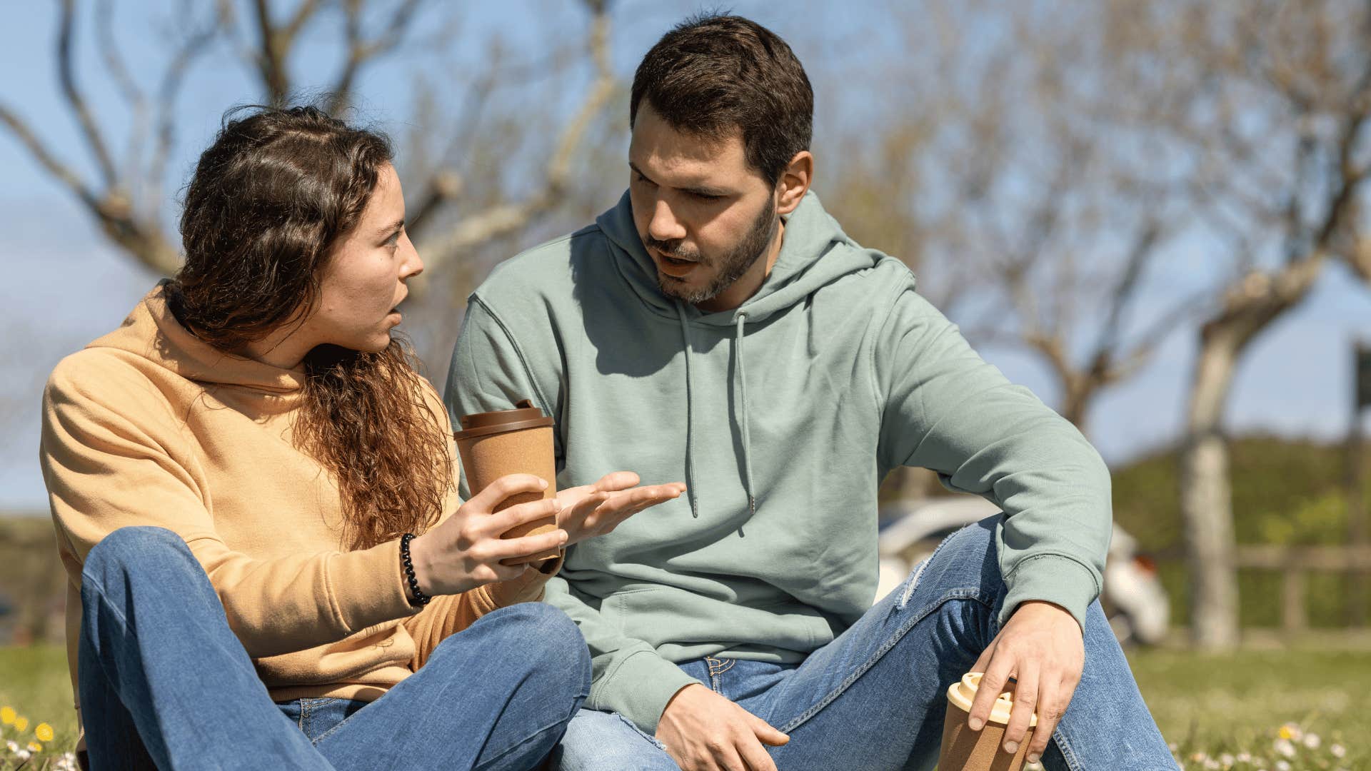 couple arguing while sitting on grass