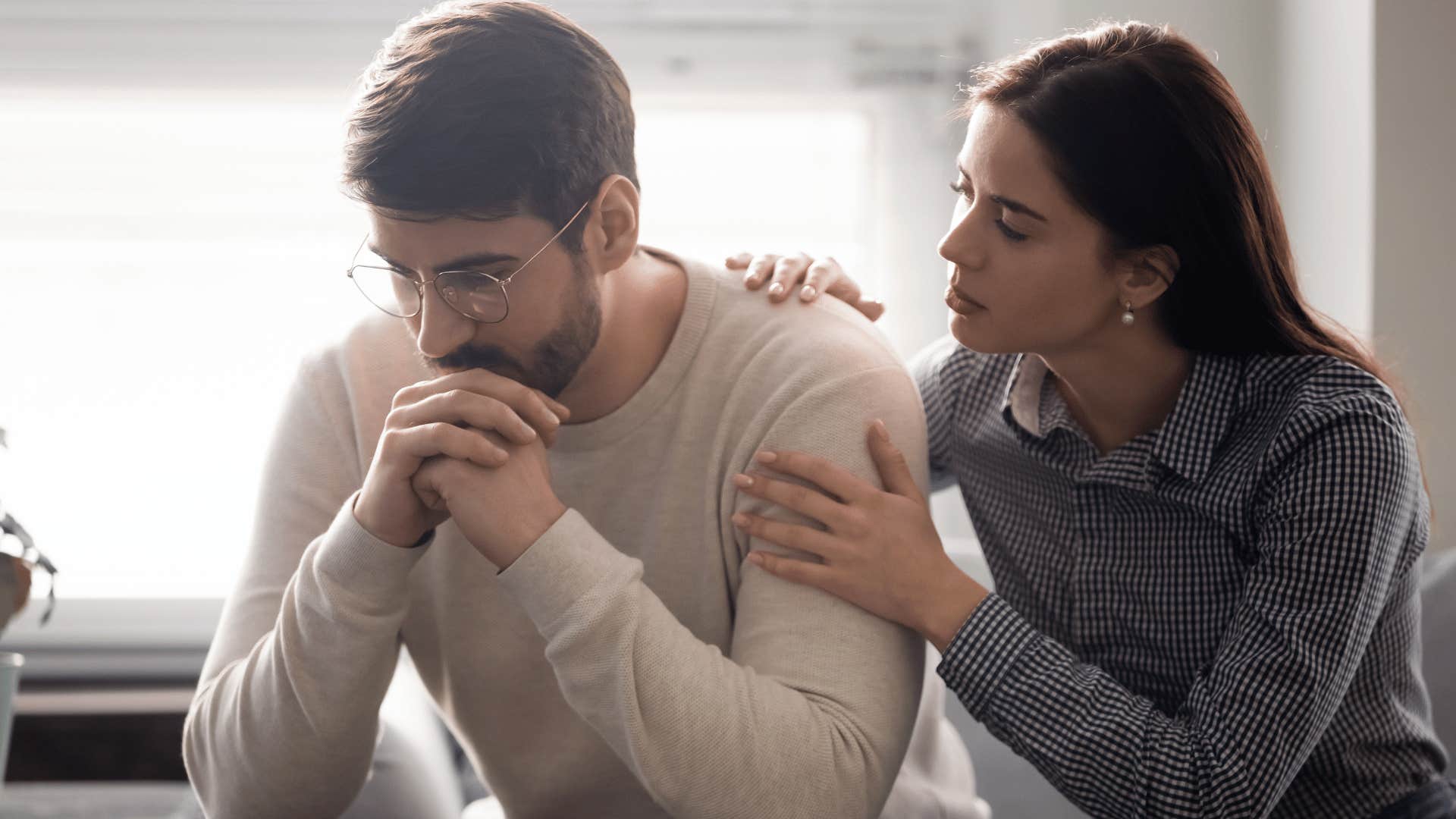 woman comforting man 