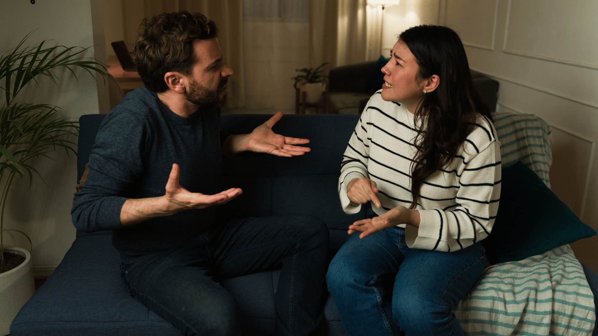 man and woman arguing on couch