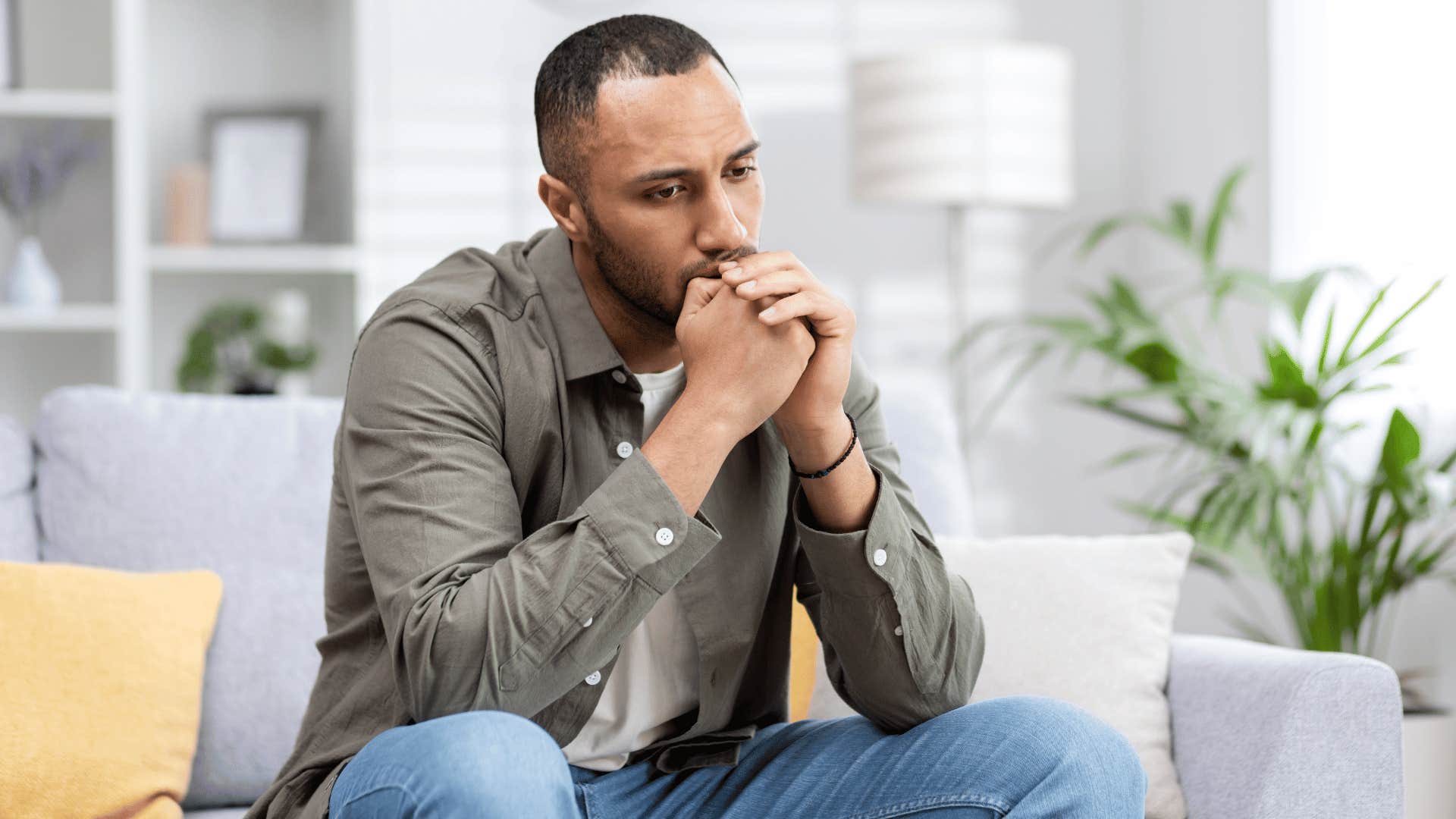 man reflecting while sitting on couch