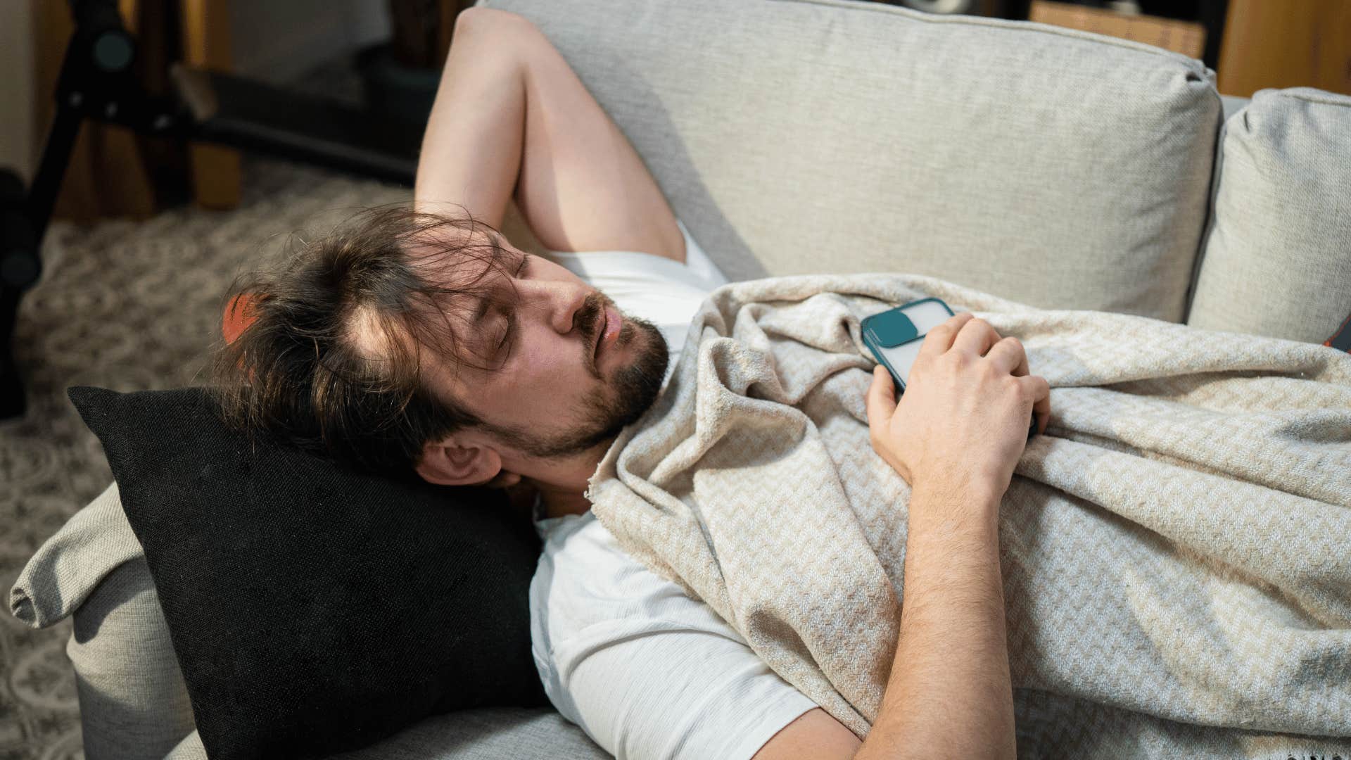 man laying down with phone on chest