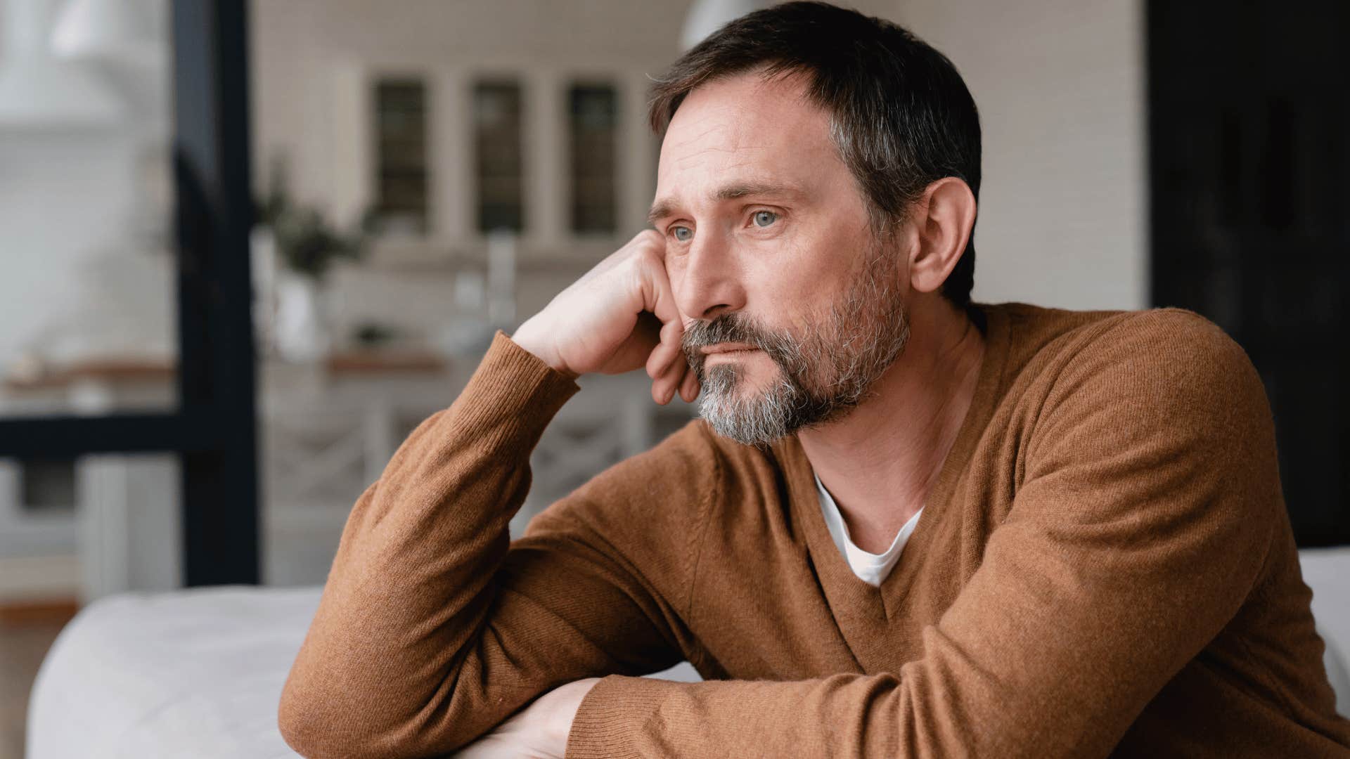 man reflecting while sitting on couch