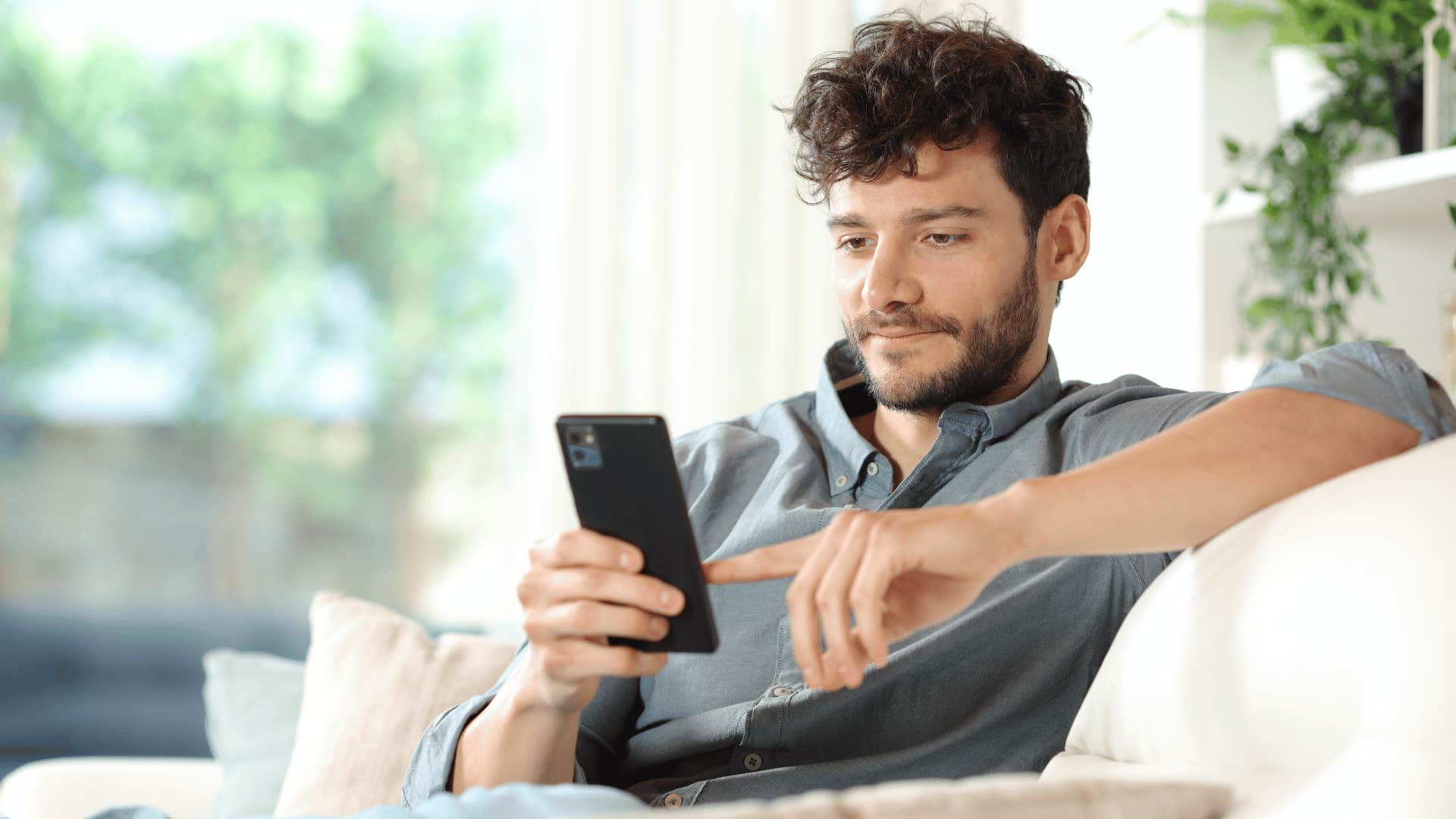 man on phone while sitting on couch 