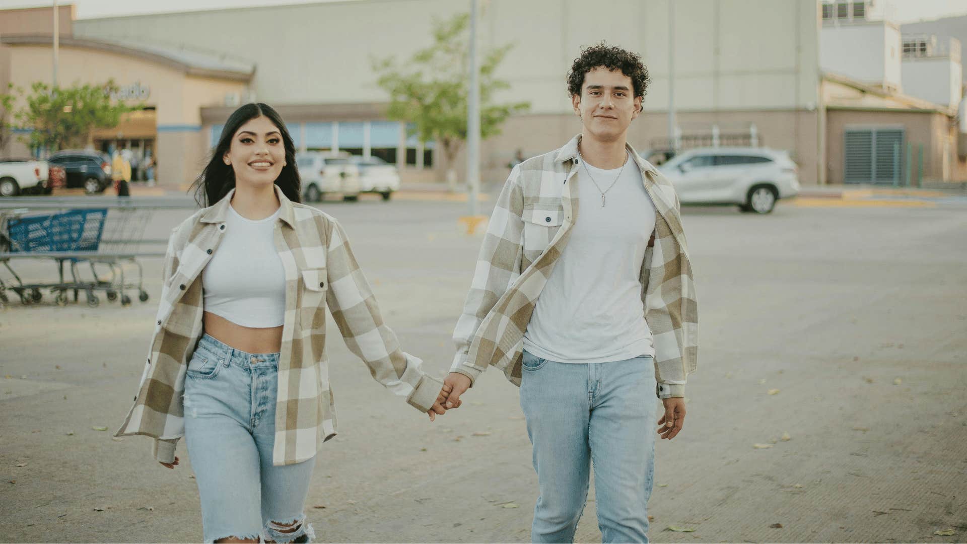 couple holding hands in a parking lot