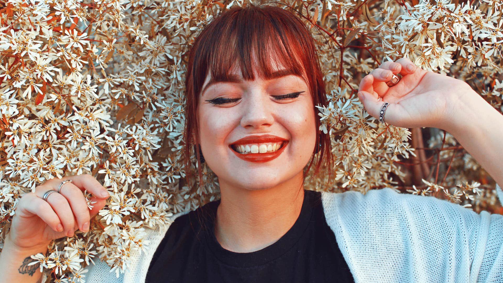 smiling confident woman in bed of flowers