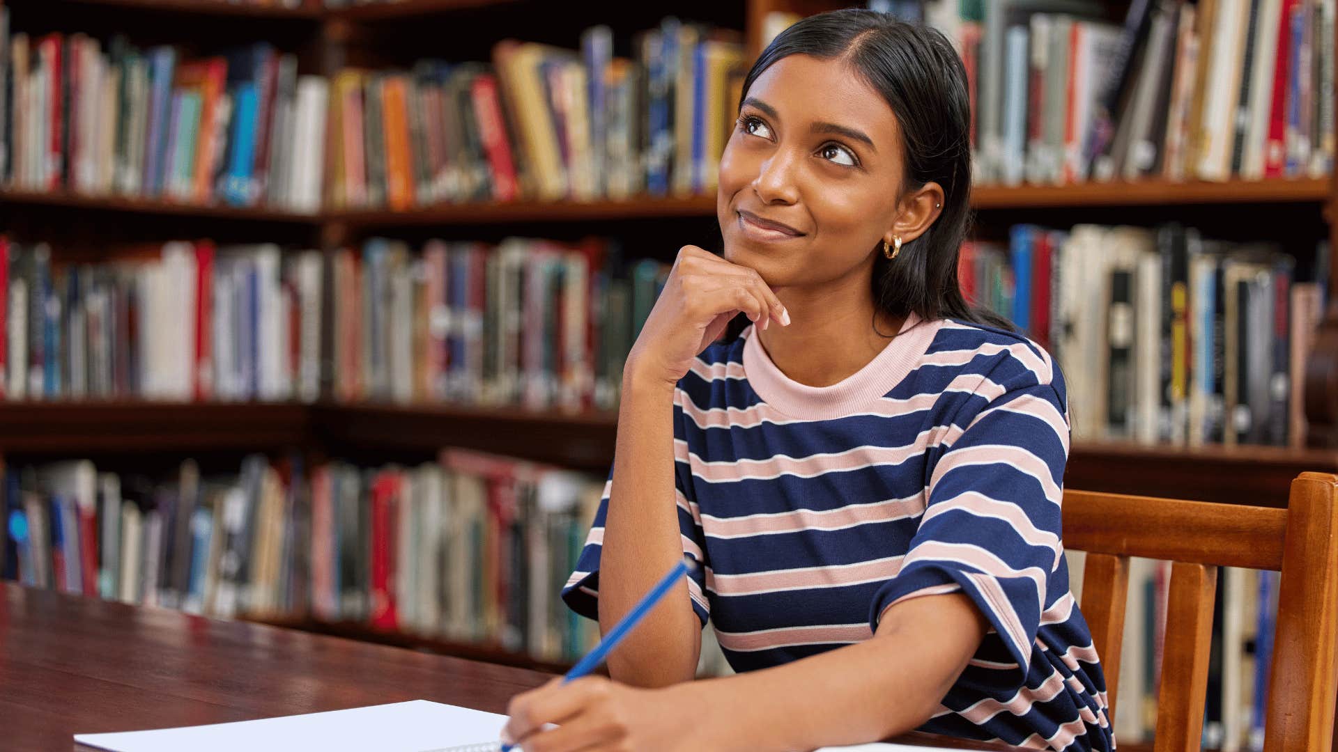 woman thinking while taking notes