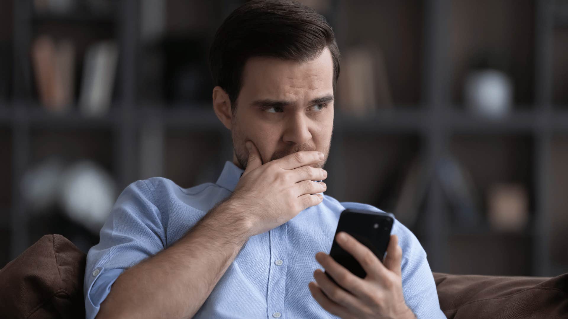 man sitting down holding his phone