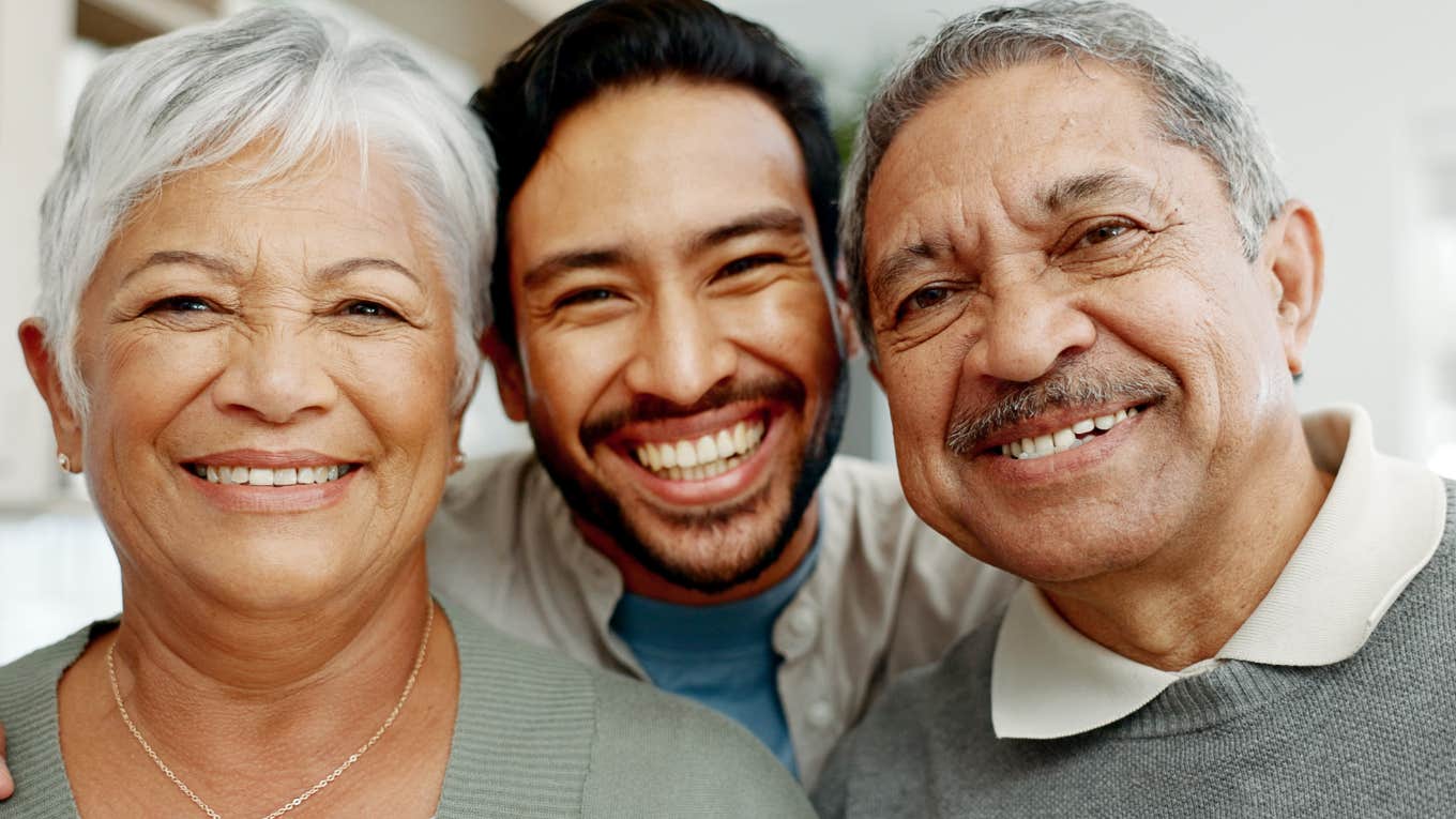 smiling man in between happy parents