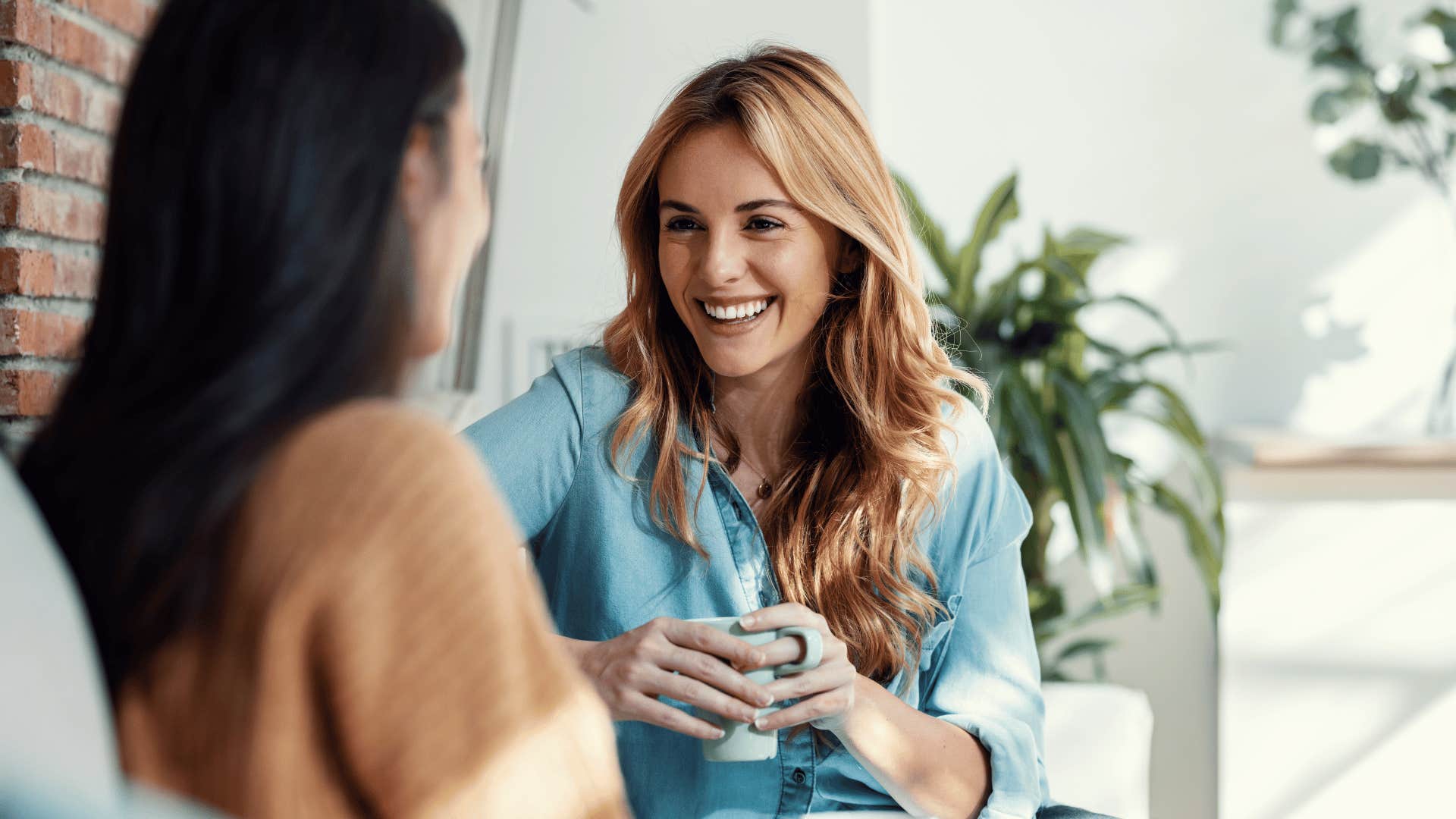 two women chatting on couch