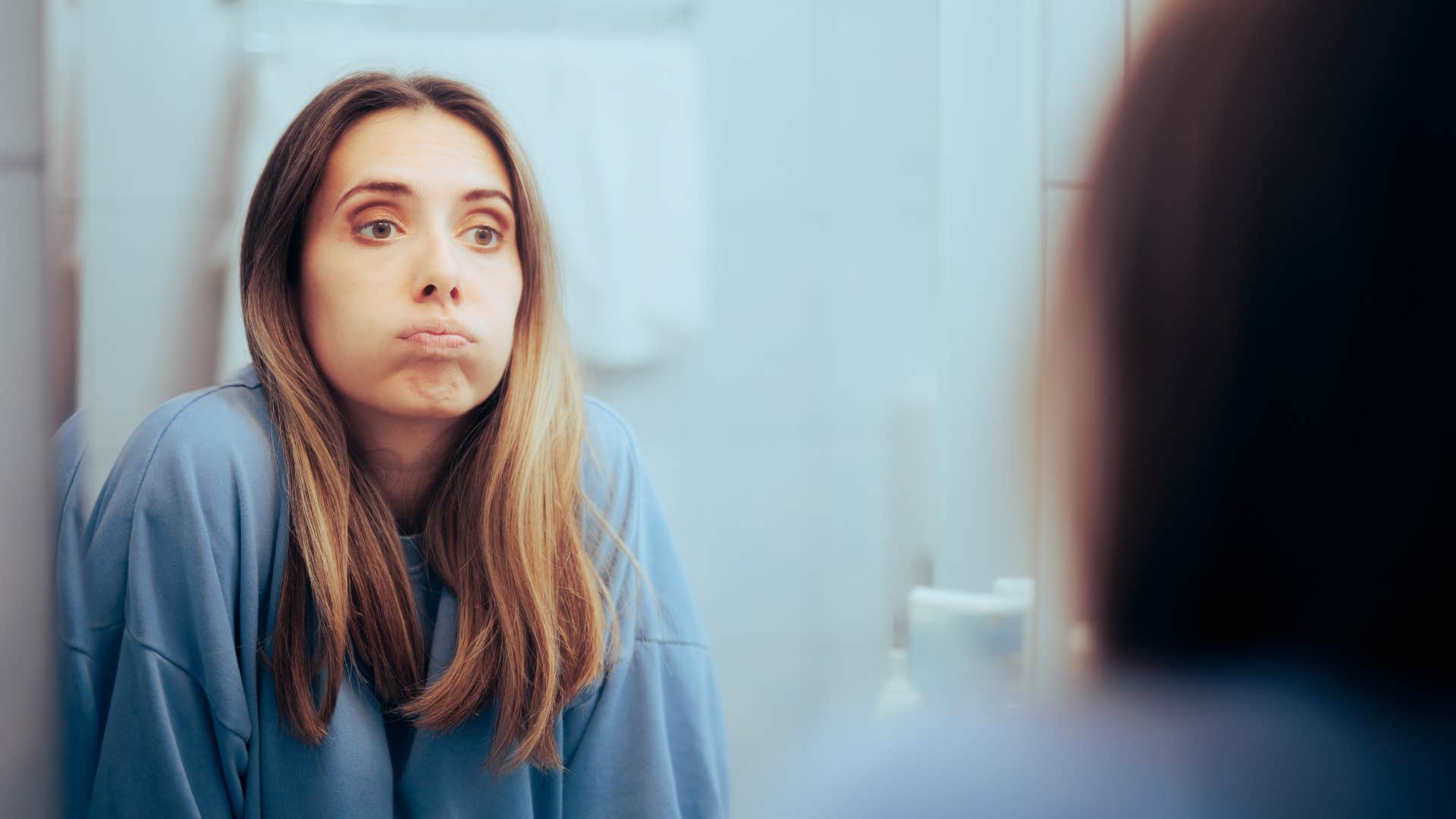 unhappy woman Looking in the nirror feeling overwhelmed