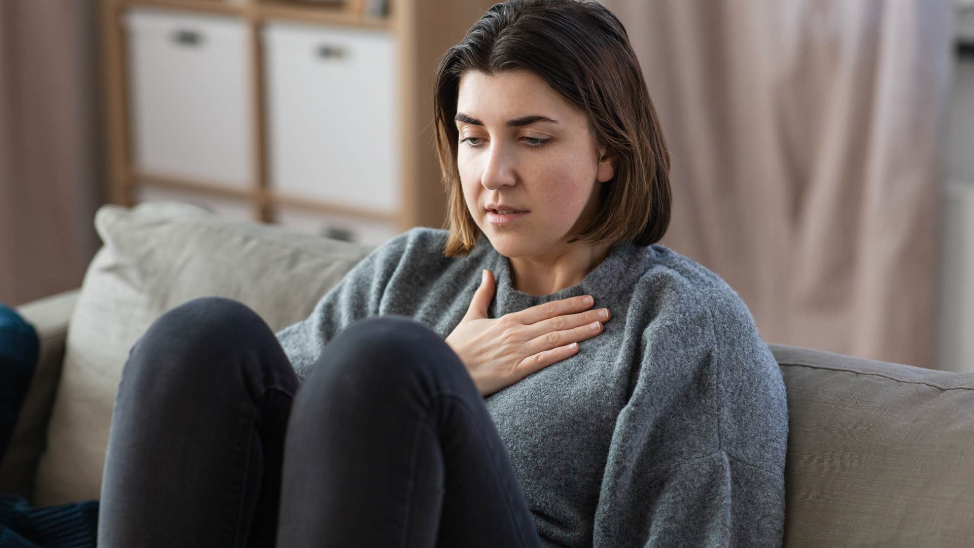 Anxious woman holding her chest.