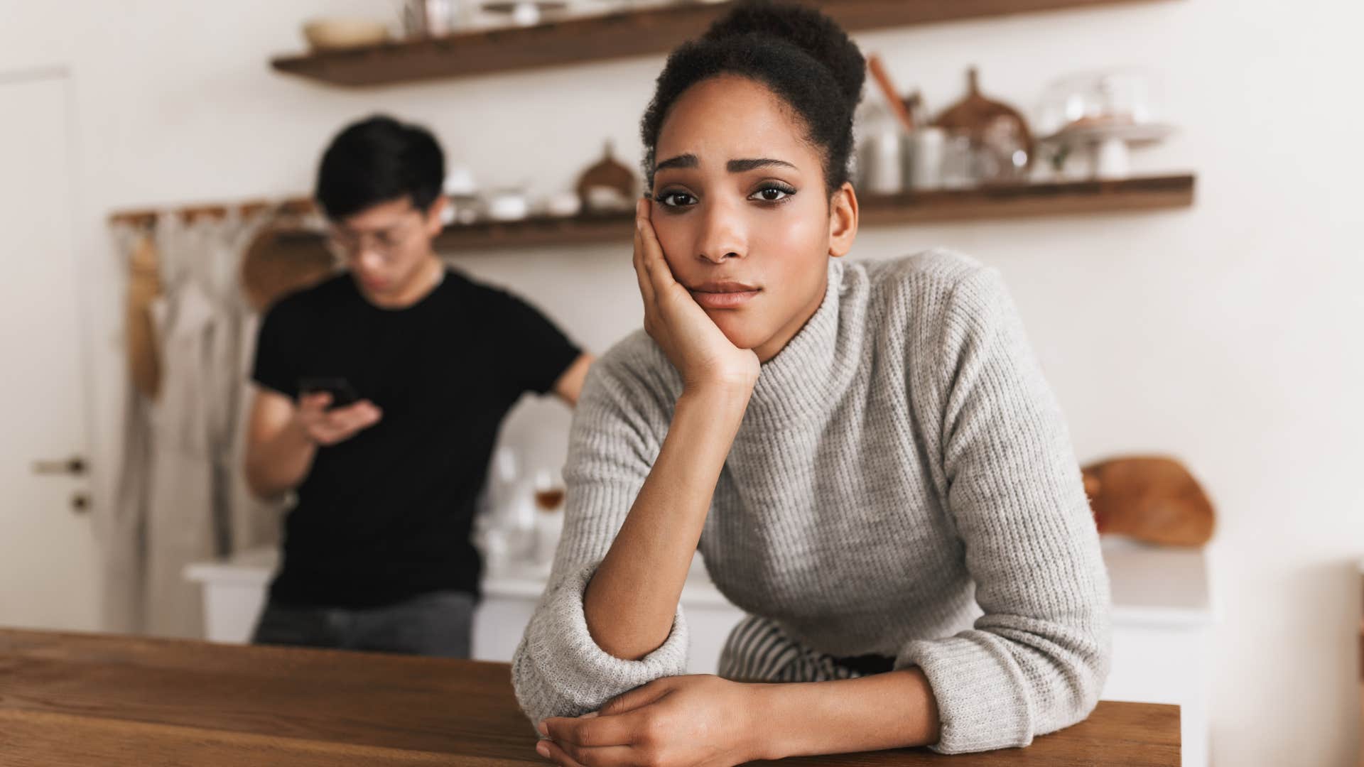 Woman looking unhappy in front of her partner.