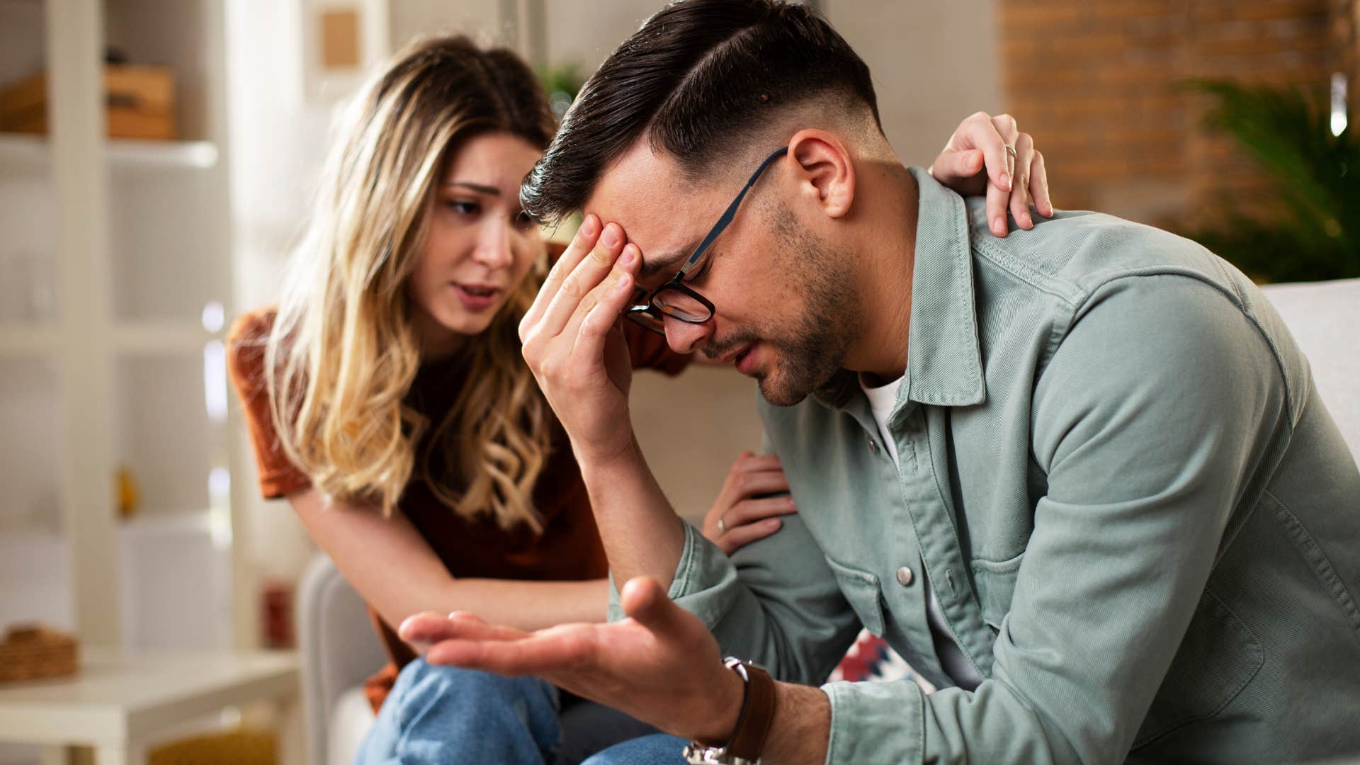 Man looking frustrated next to his girlfriend.