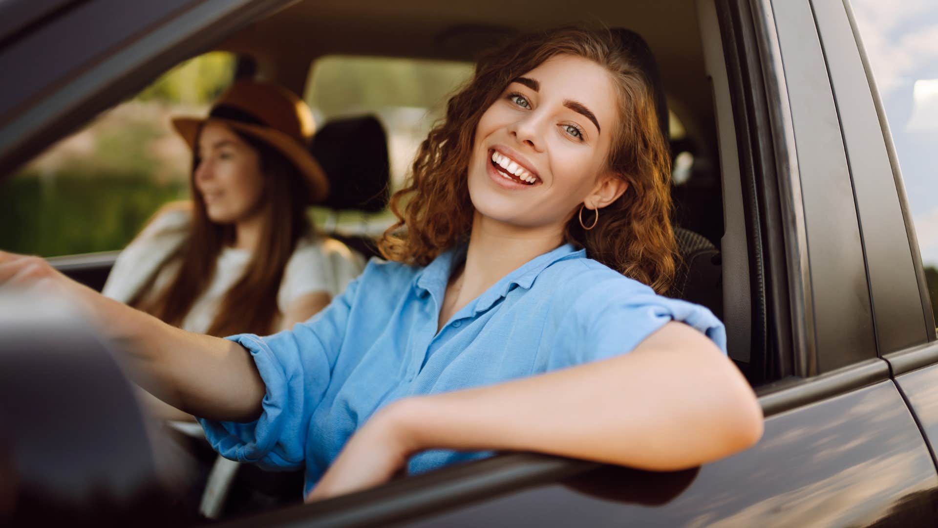 Woman smiling while driving her car.