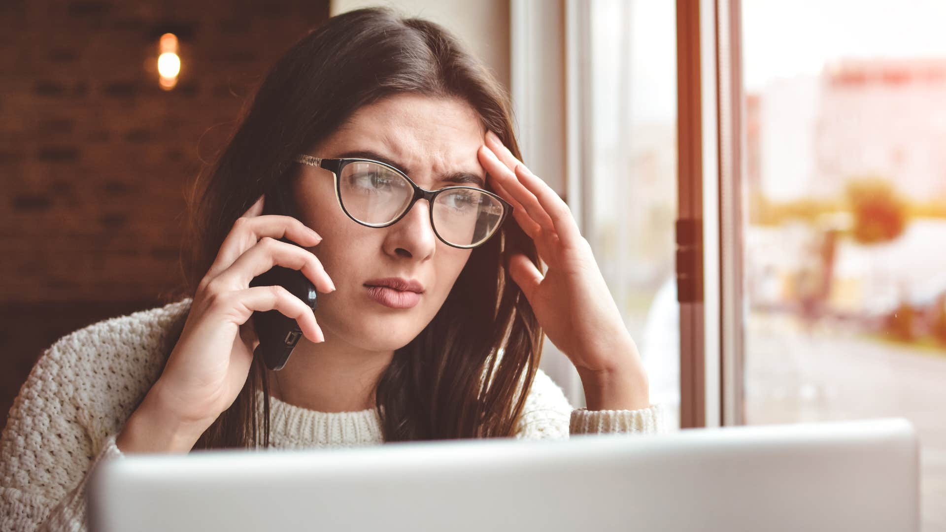 Woman looking annoyed while talking on her phone.