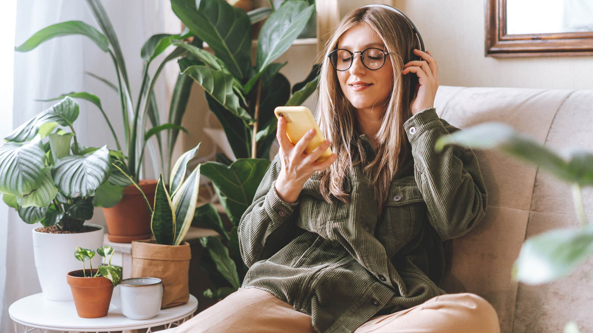 Woman smiling and listening to music at home.