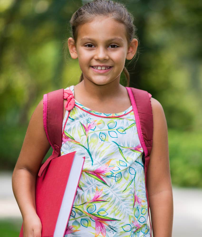 little girl smiling on her way to school