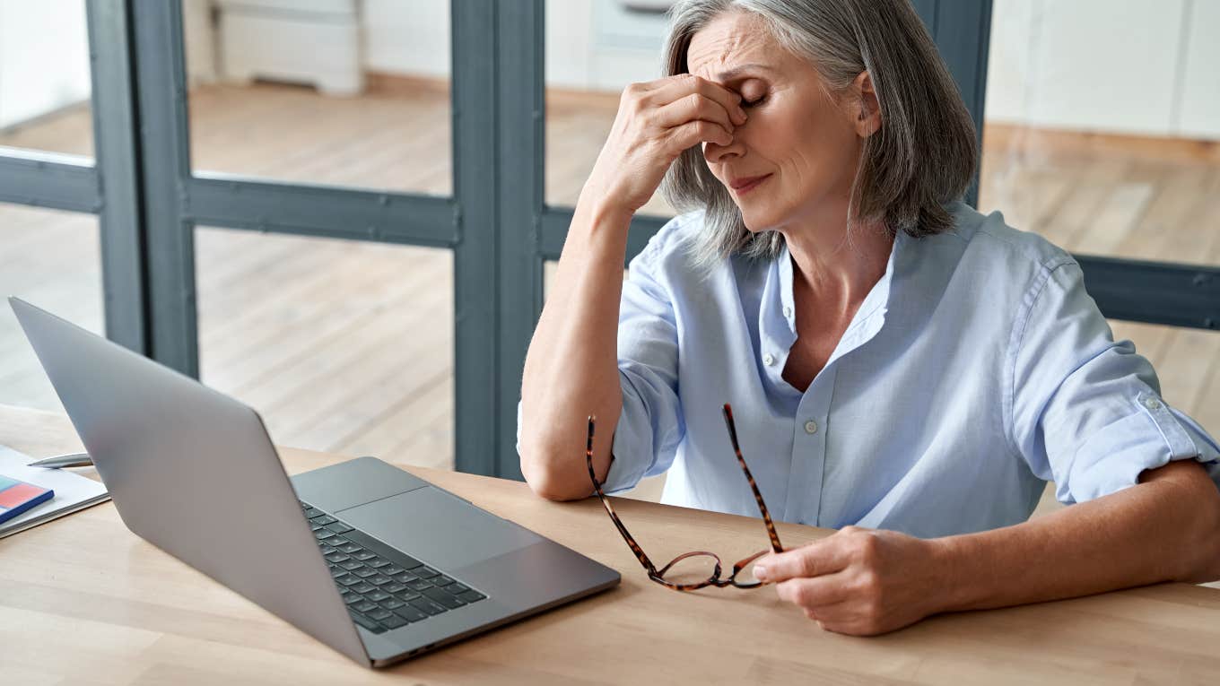 frustrated older woman sitting in front of laptop