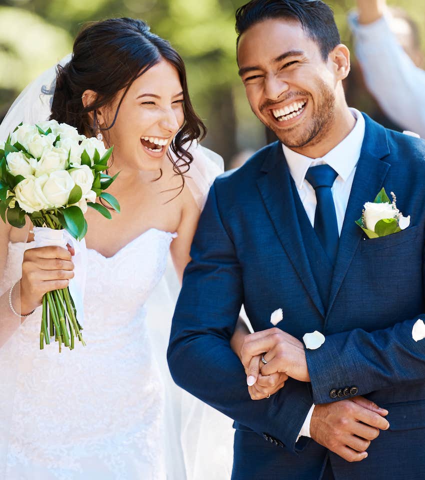 Couple smile while locking arms at their wedding