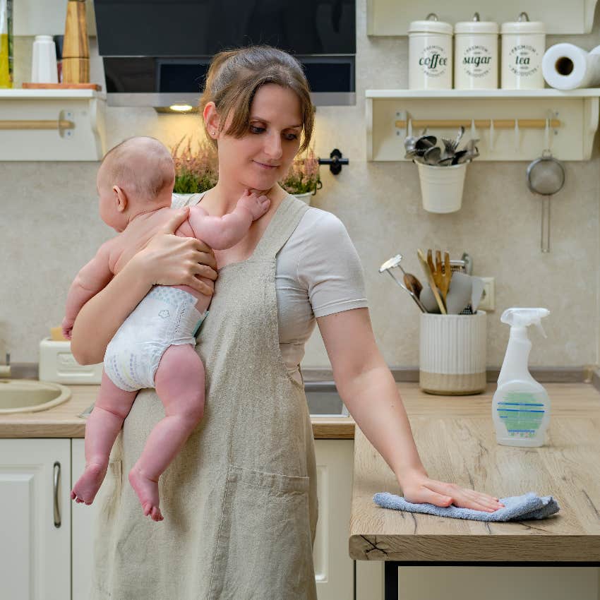 Stay-at-home mom holding baby and cleaning