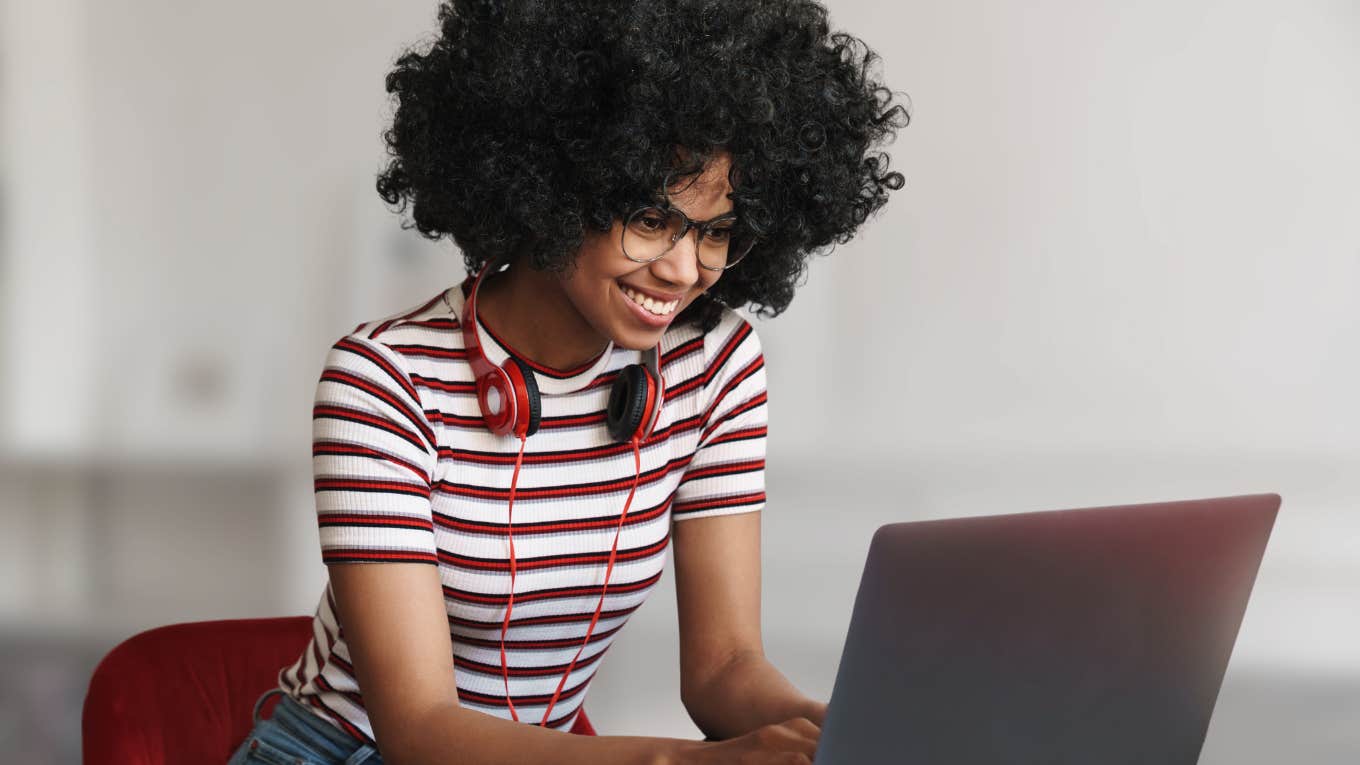 Woman looking focused writing an appreciative message on her laptop. 