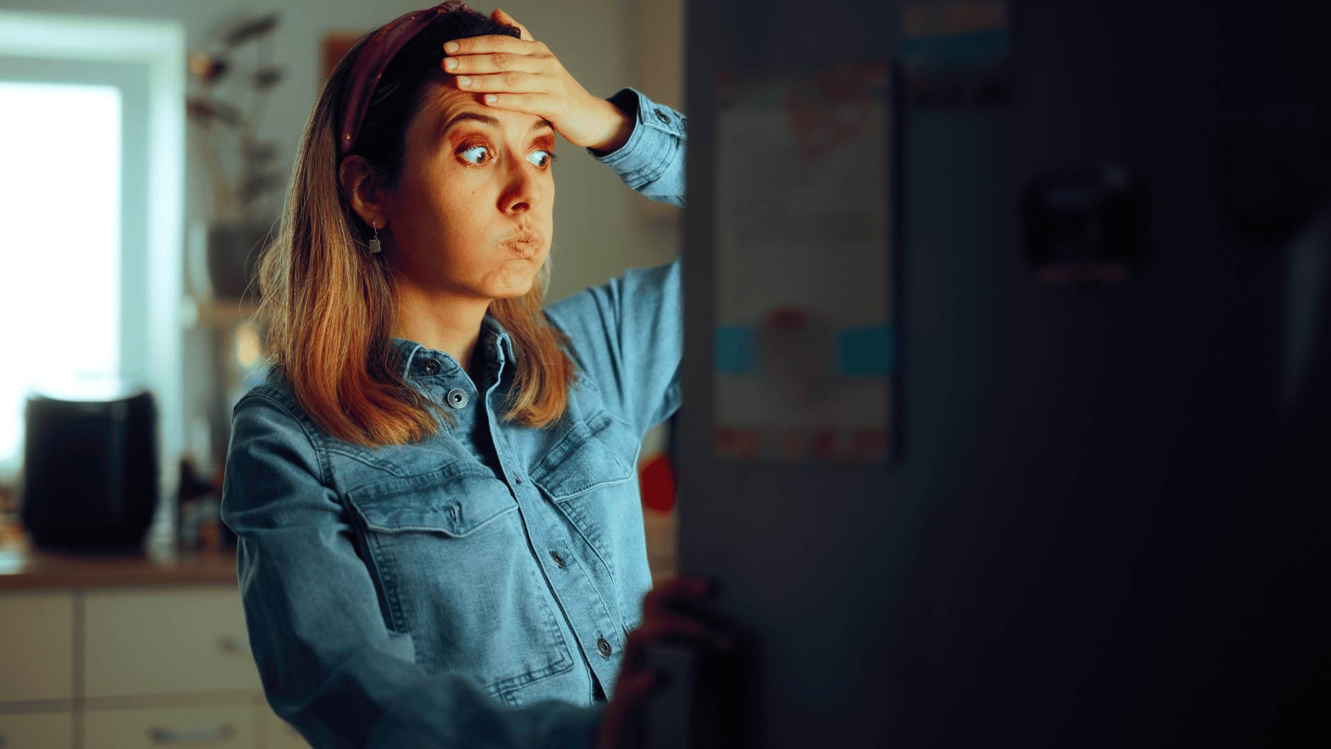 woman looking at fridge stressed out 