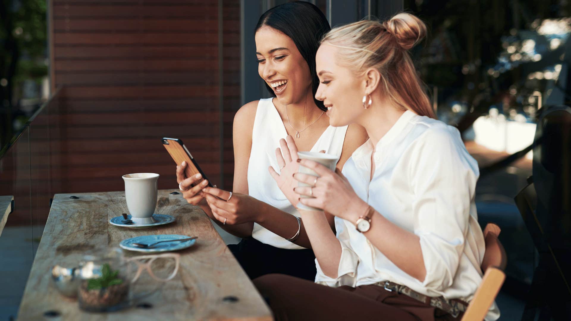 women gossiping and looking at phone