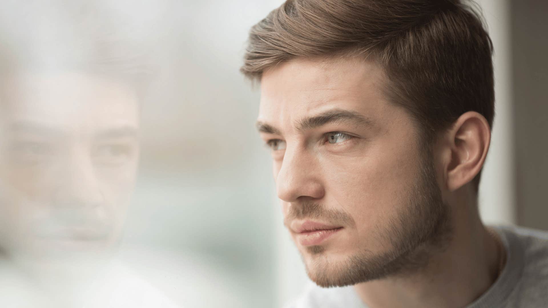 man looking out a window