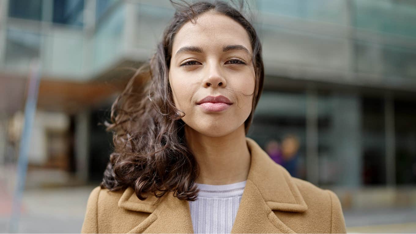 Cold-hearted woman staring right at the camera outside