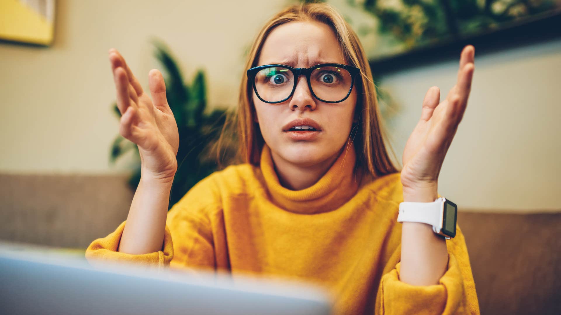 Woman looking confused with her hands in the air