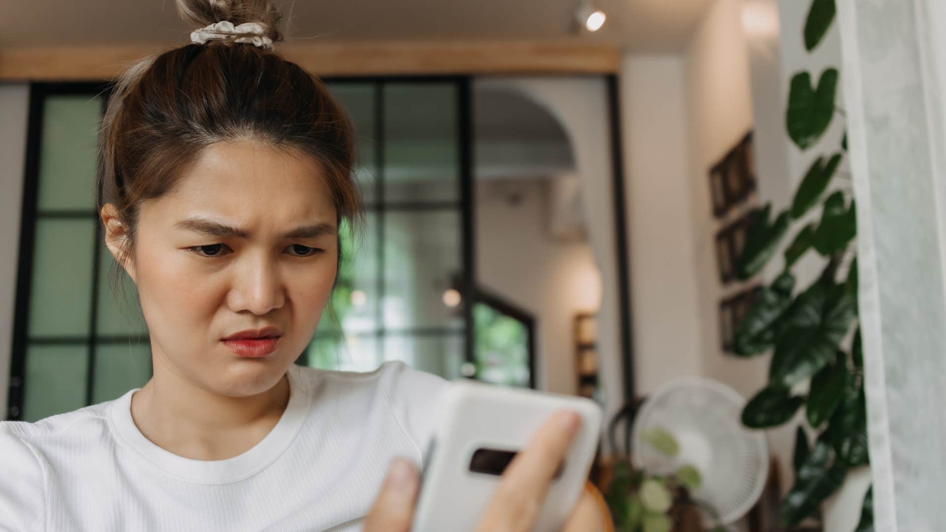 Woman looking confused staring at her phone. 