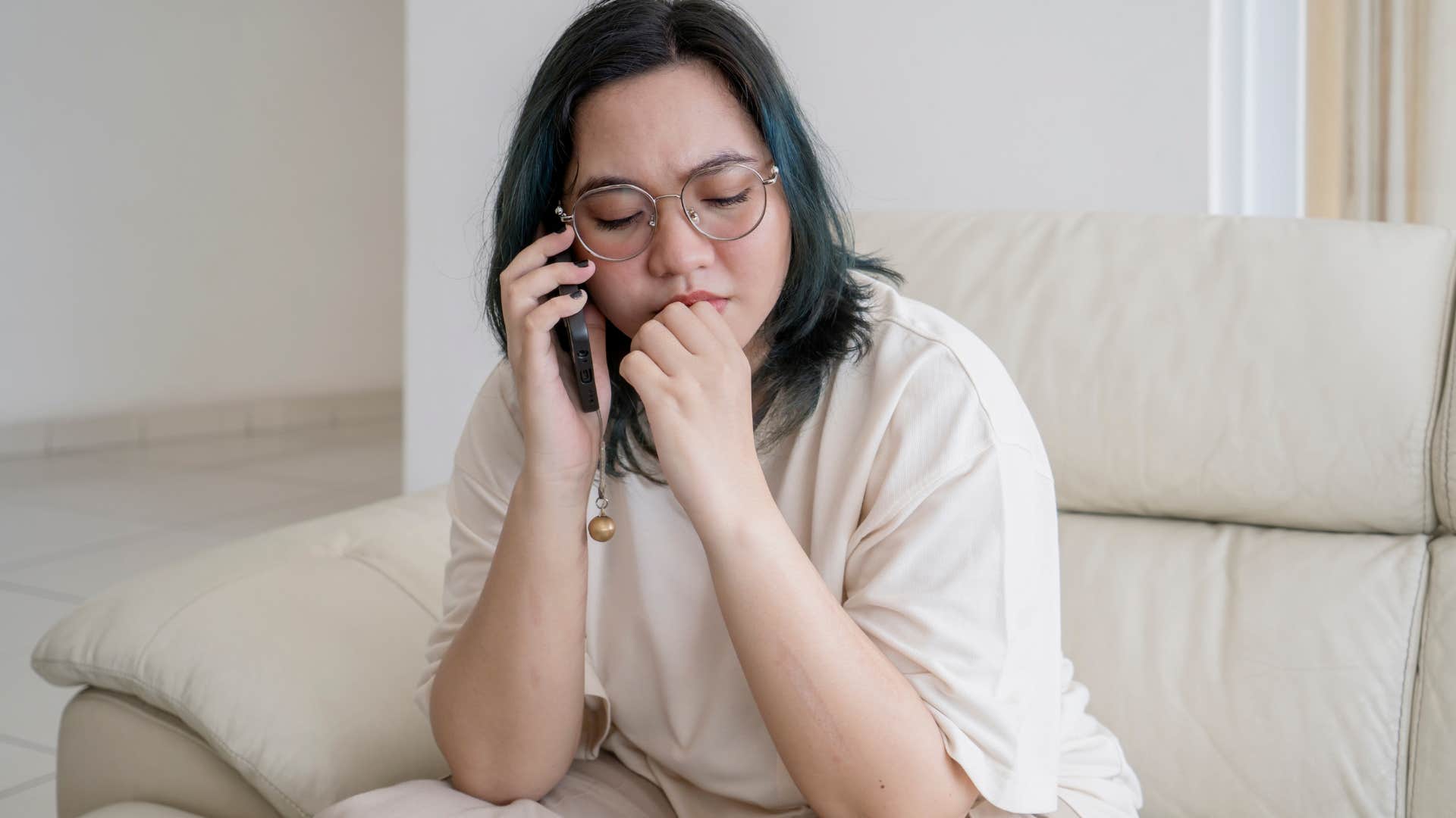 Woman looking nervous while talking on the phone. 